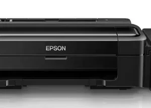 Epson L130 single-function ink tank printer in black, featuring compact design with visible front ink tanks and USB connectivity, placed on a modern workspace desk